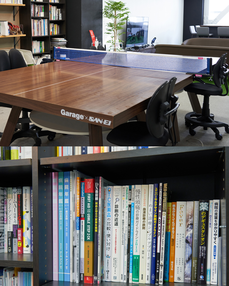 イメージ：卓球台にもなるユニークなテーブル、書棚には医療やシステムなどの書籍が多数。