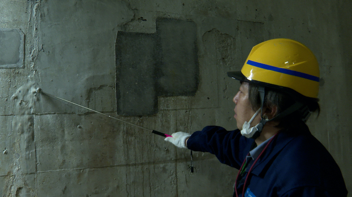 画像：須田さんによる壁の点検の実演の様子